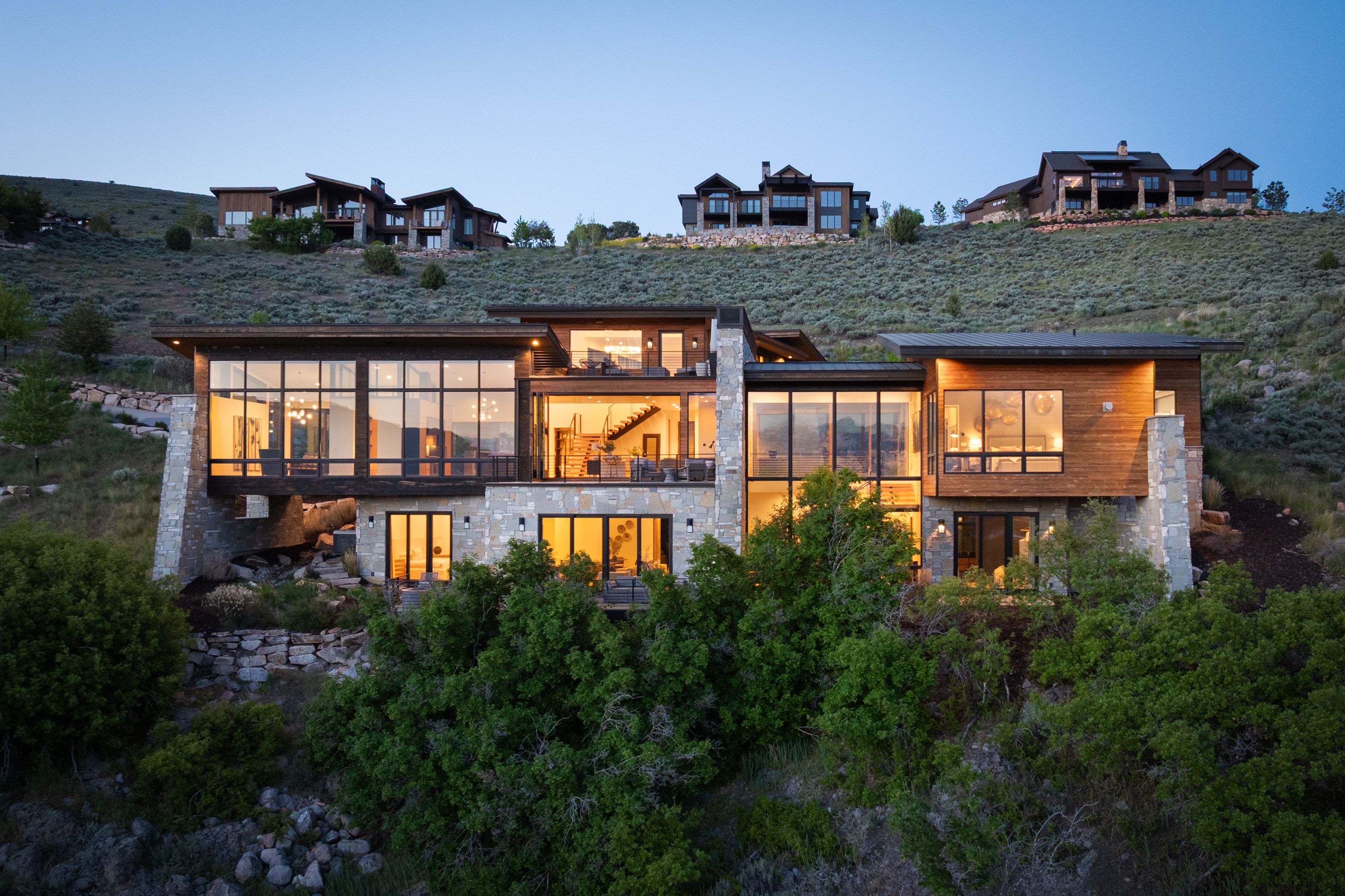 Modern architectural design featuring extensive glass fenestration, wood siding, and stone accents
