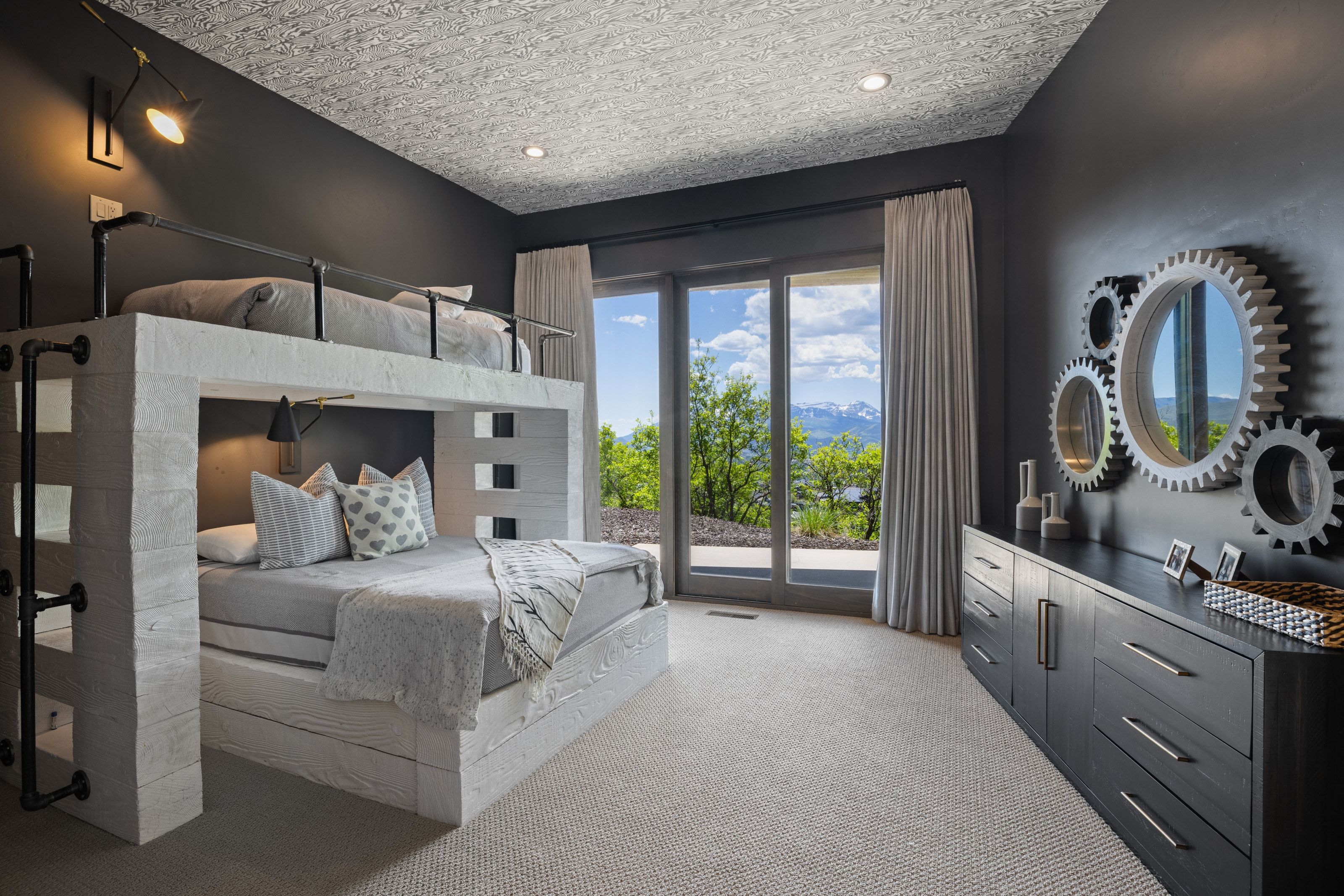 Spacious room featuring a built-in bunk bed structure with a ladder, recessed lighting, and dark wall finishes