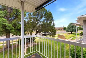 Elevated balcony featuring white railings and an outdoor overhead light