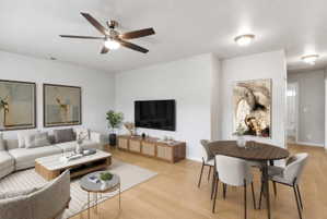 Open-concept living area with light wood-finish flooring, a contemporary ceiling fan, recessed lighting, and white wall finishes