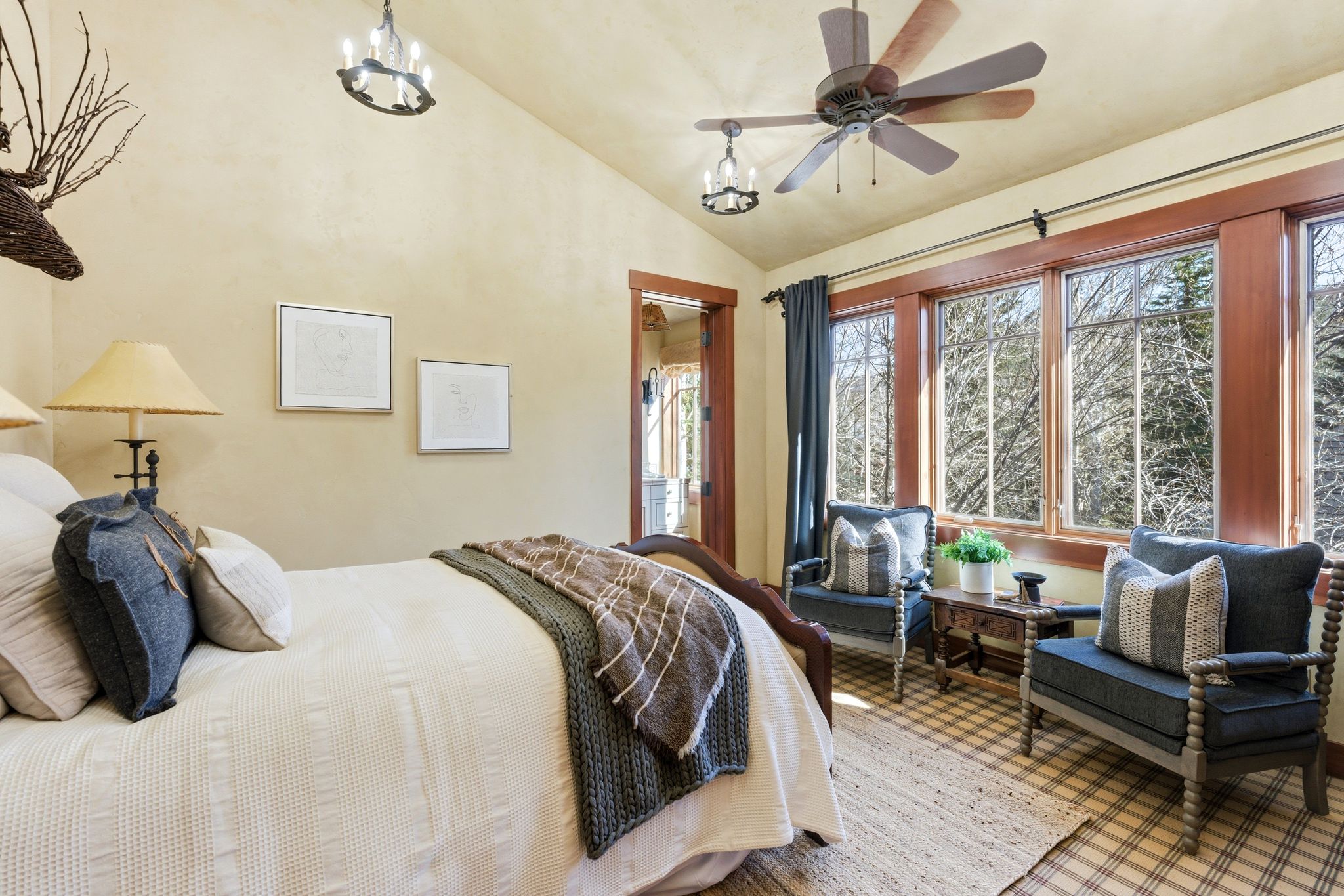 Vaulted ceiling bedroom featuring wood-finish flooring and a multi-pane window wall