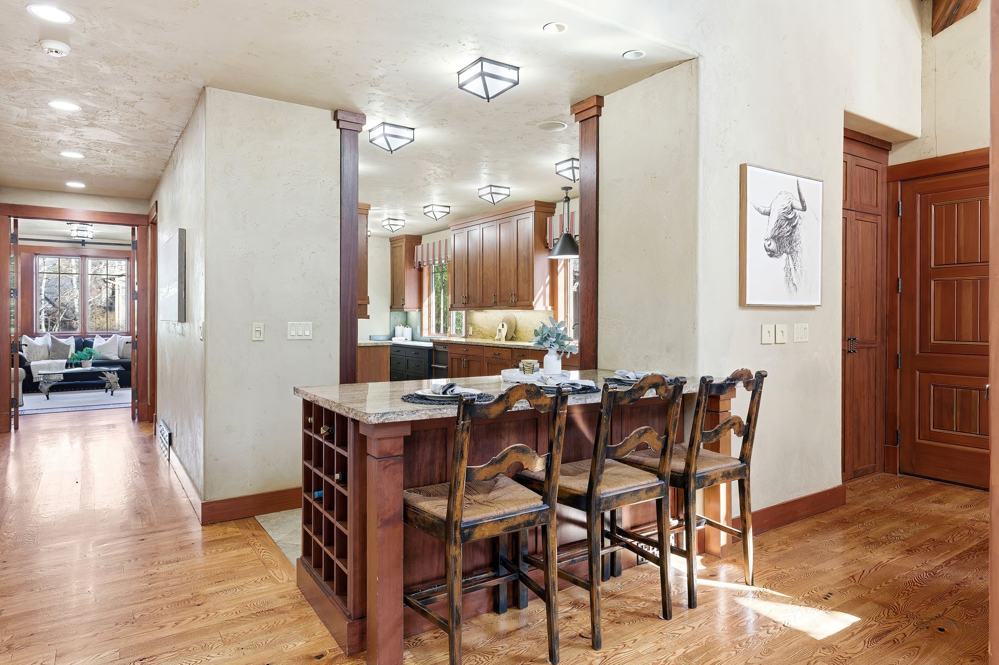 Kitchen island with granite-style countertop, integrated wine rack, and pendant lighting