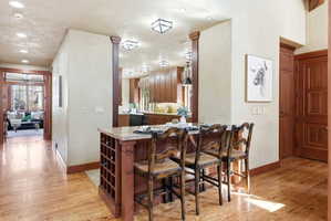 Kitchen island with granite-style countertop, integrated wine rack, and pendant lighting