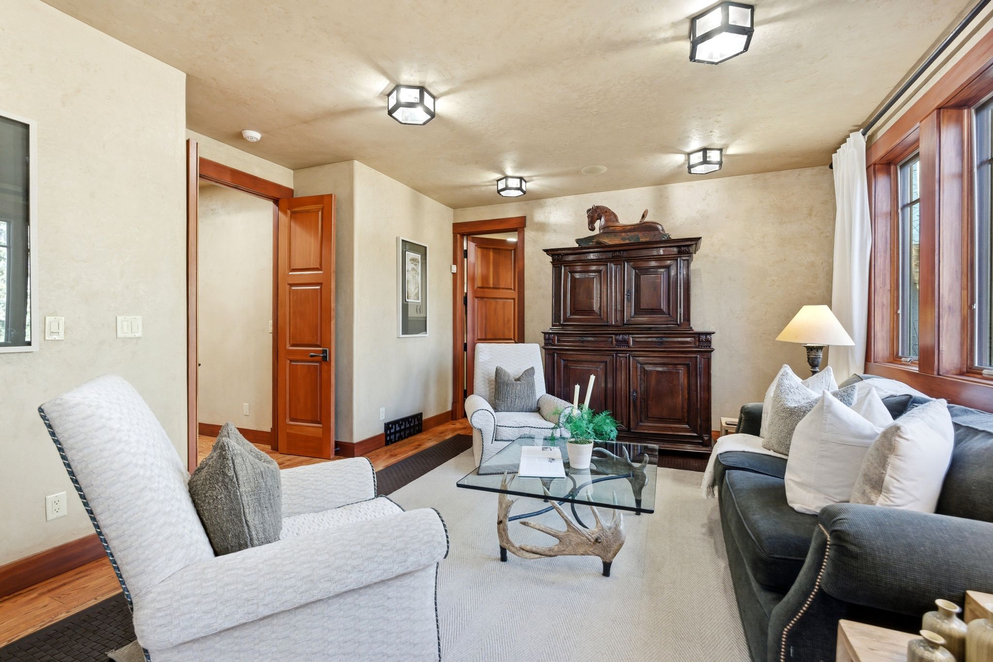 Living area with wood-finish trim and doors, textured wall finishes, and recessed ceiling lighting