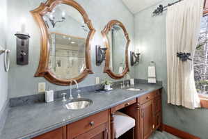Dual vanity with wood-finish cabinetry and integrated seating area