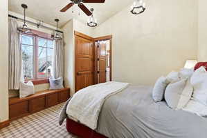Window seat with storage cabinetry, wood-framed casement windows, and plaid carpet