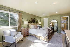 Spacious room featuring textured green walls, recessed lighting, and a large window