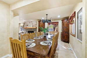 Dining room featuring a wood-finish dining table and chairs, tile flooring, and a wrought iron chandelier