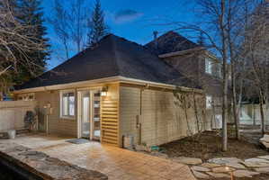Exterior featuring a stamped concrete patio, stone retaining wall, and natural stone stepping pavers