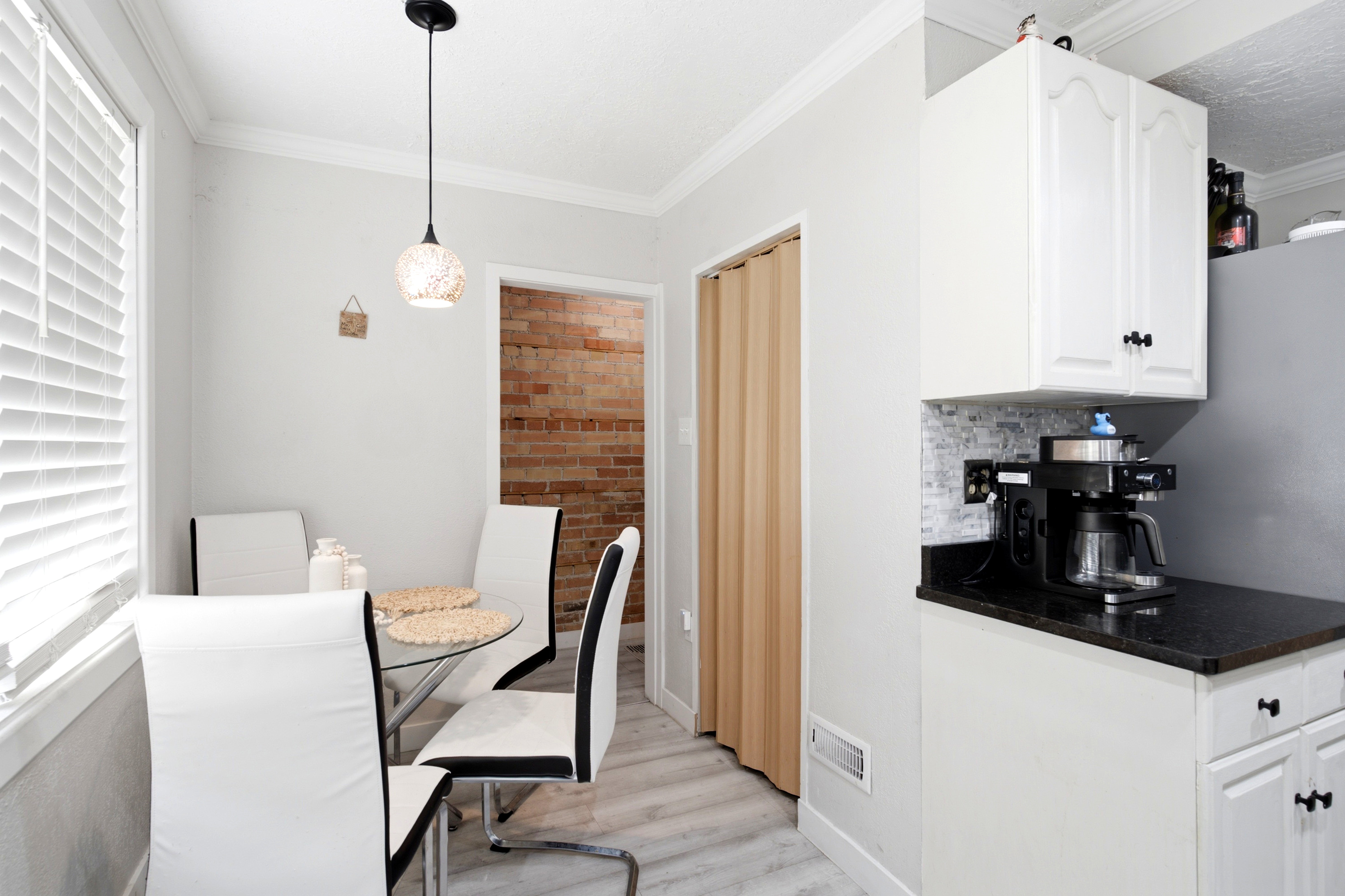 Kitchenette featuring white cabinetry, dark countertops, and a tiled backsplash