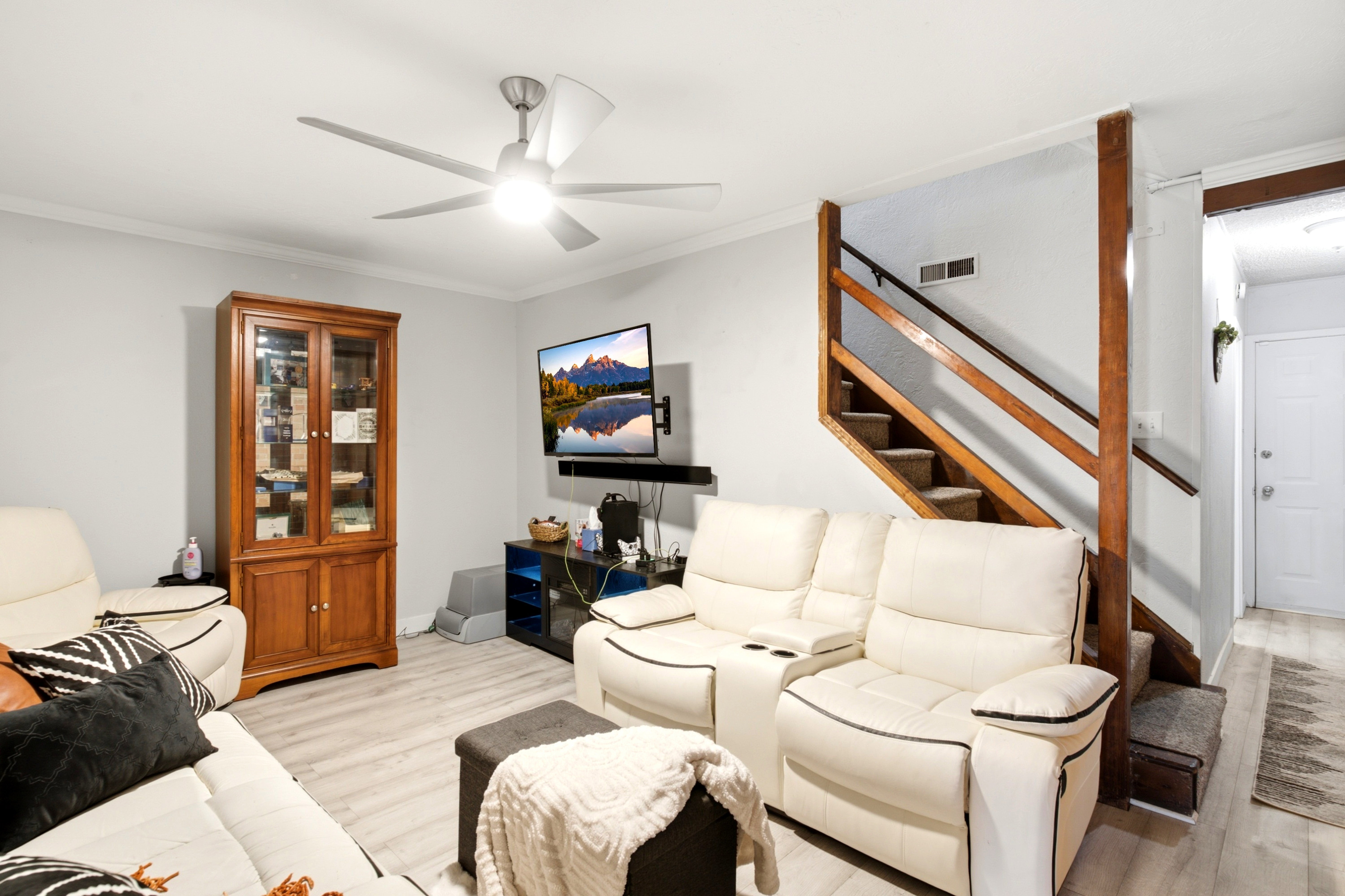 Living area featuring light wood-finish flooring and a contemporary ceiling fan