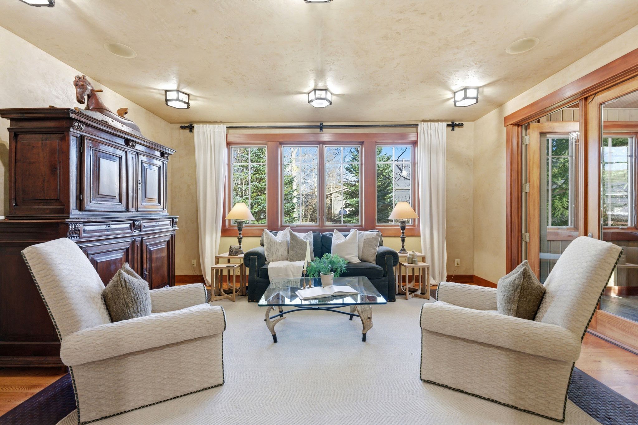 Living area featuring a bay window with wood trim, recessed lighting, and a neutral wall finish