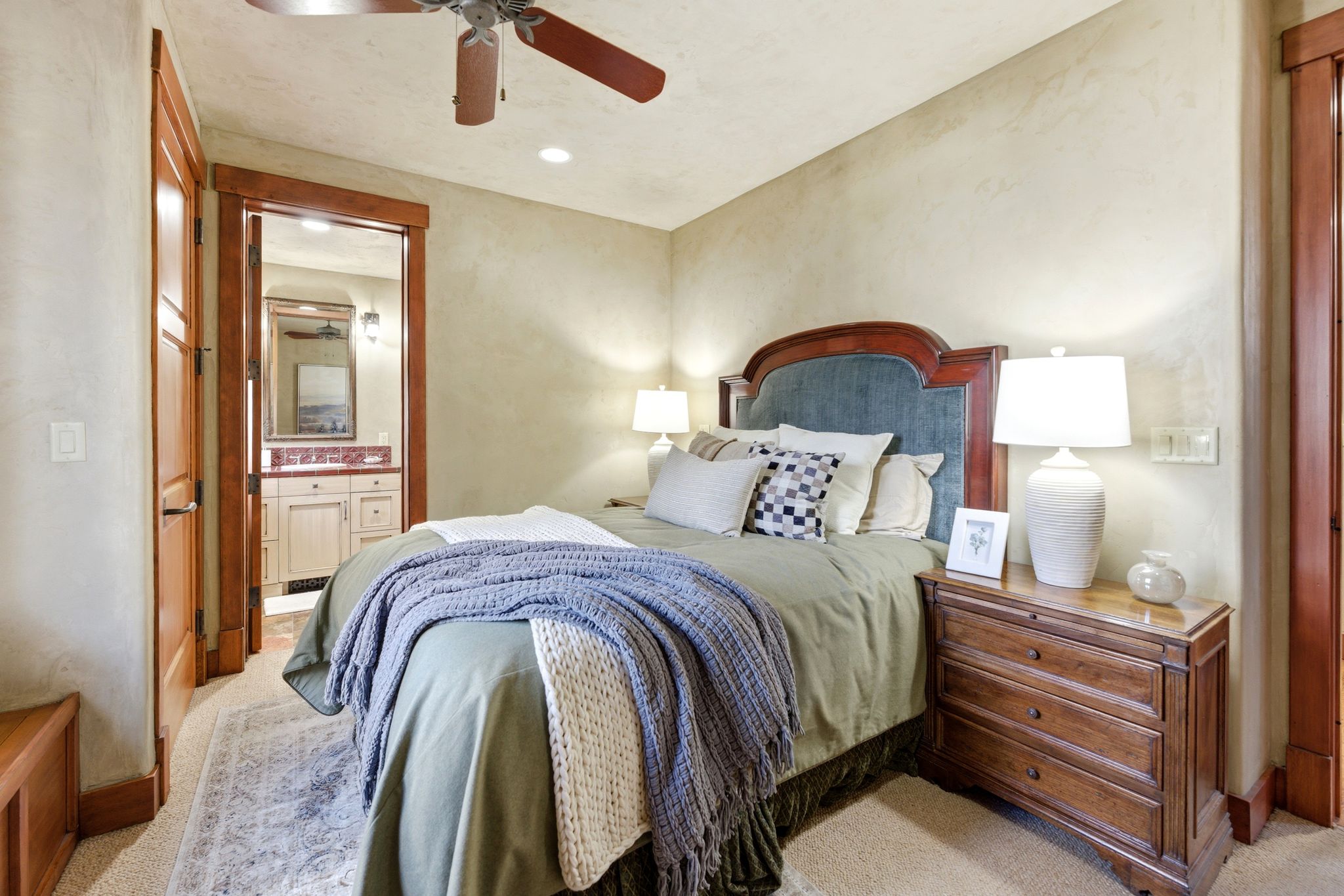 Carpeted bedroom featuring a ceiling fan, recessed lighting, wood-trim doorways, and a bathroom vanity with a red countertop