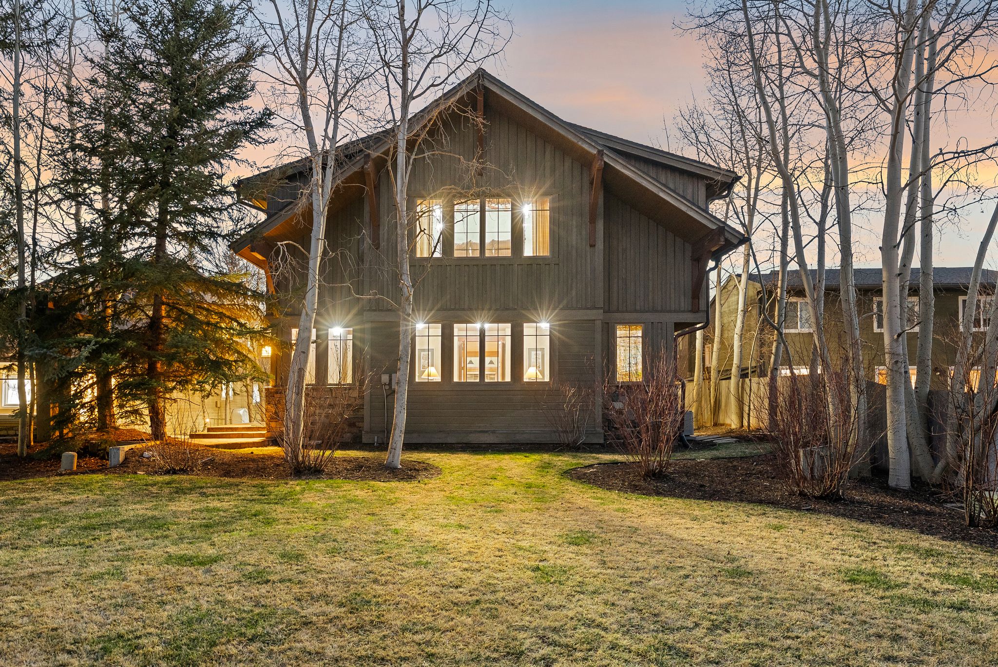 Wood-sided exterior featuring multiple windows and a stone foundation