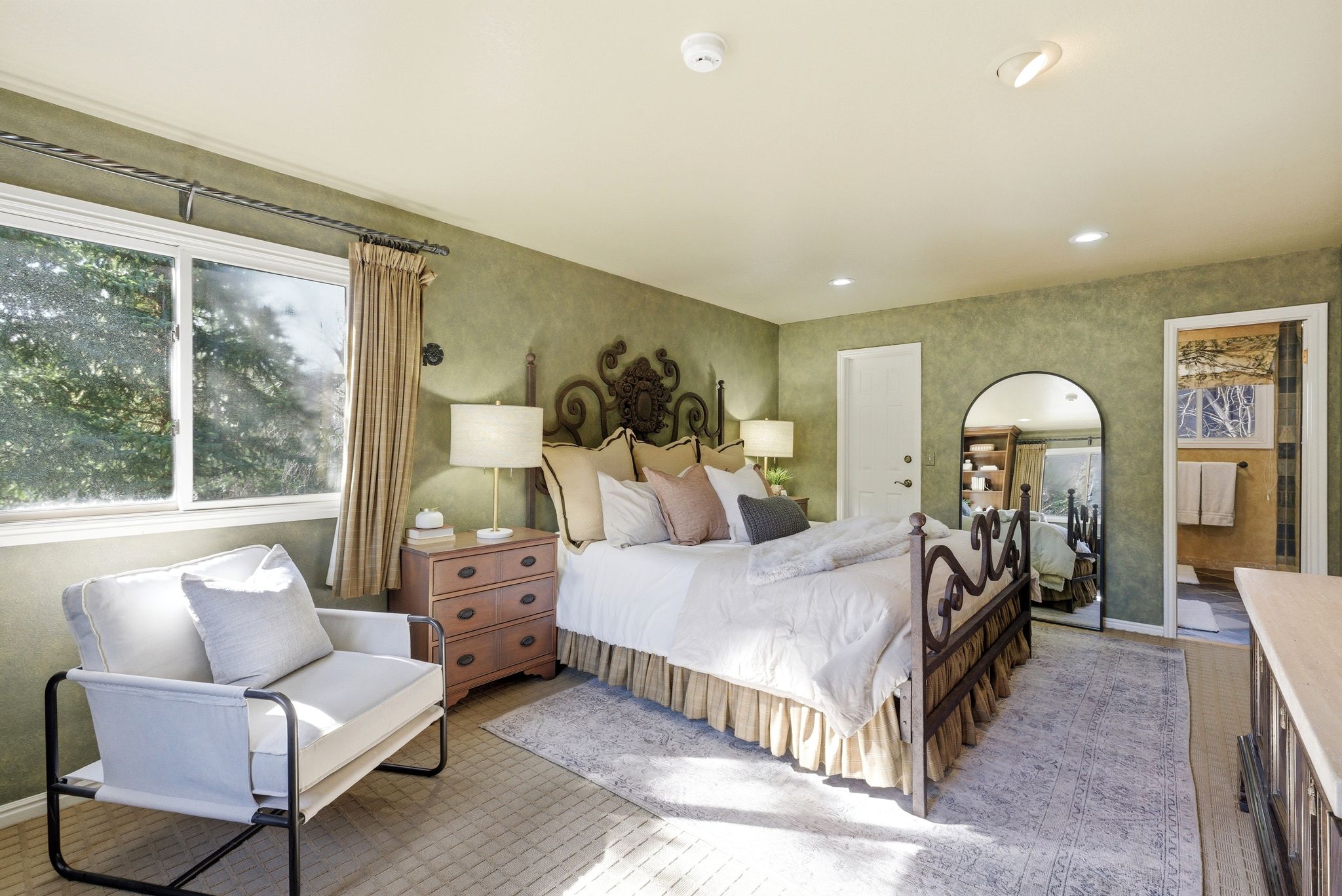 Bedroom featuring textured wall finishes, recessed lighting, and a window with exterior views