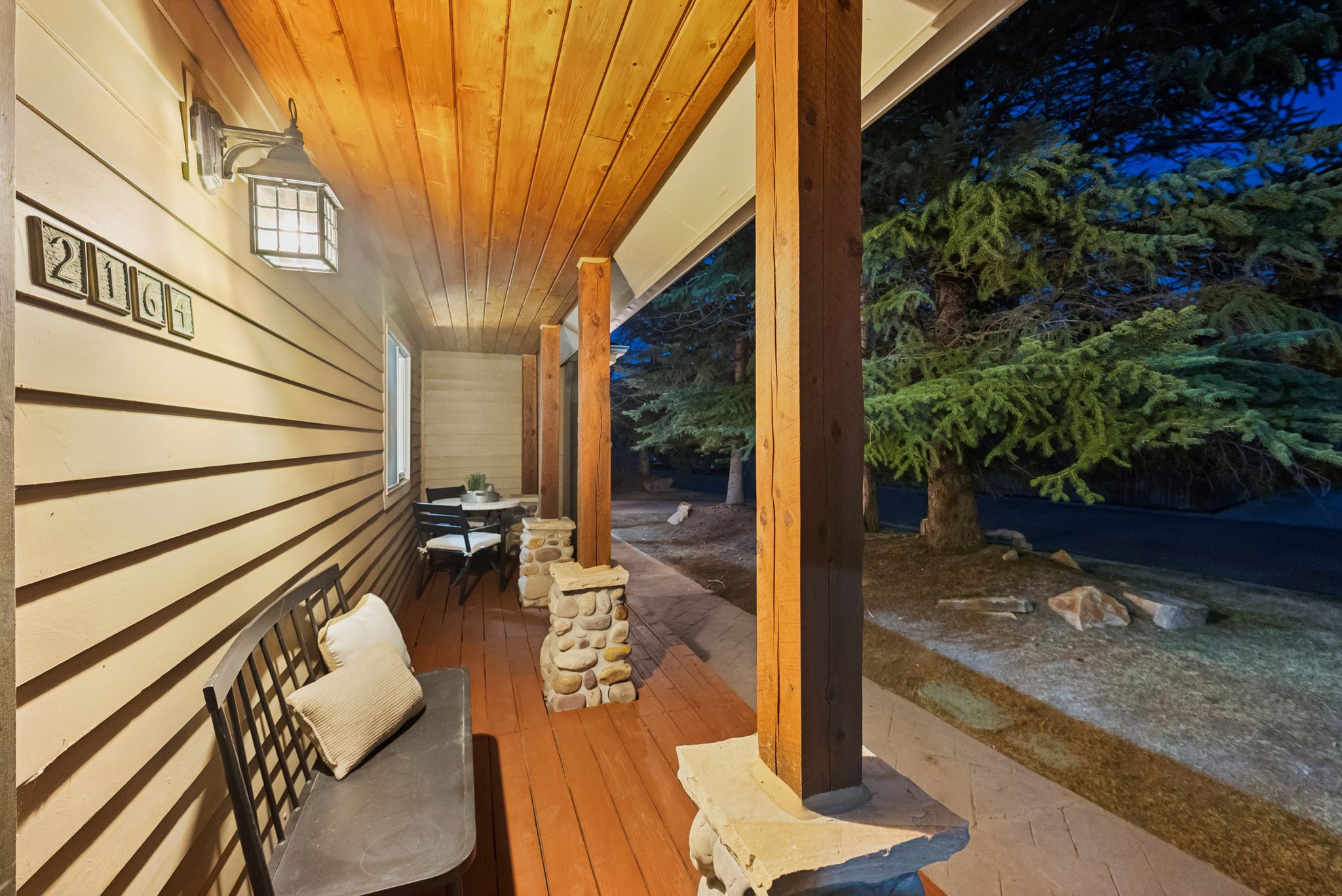 Covered porch featuring wood plank flooring and a natural wood plank ceiling