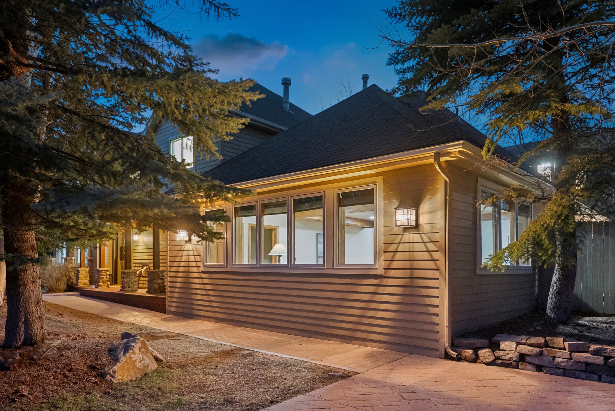 Exterior featuring horizontal siding, multiple large windows, and a dark shingle roof