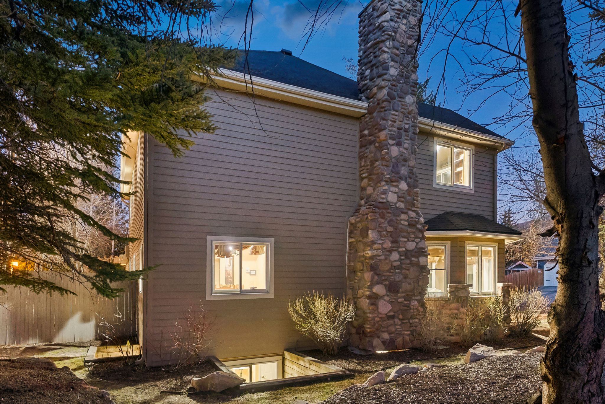 Stone chimney and bay window feature on this siding exterior home