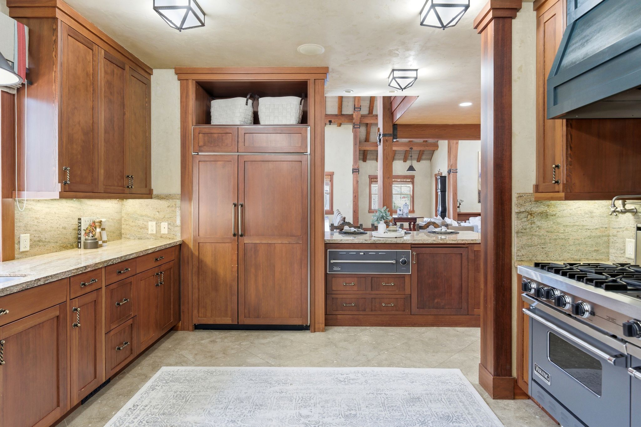 Gourmet kitchen featuring rich wood cabinetry, stone countertops, integrated panel-ready refrigerator, a commercial-style range, and built-in microwave drawer
