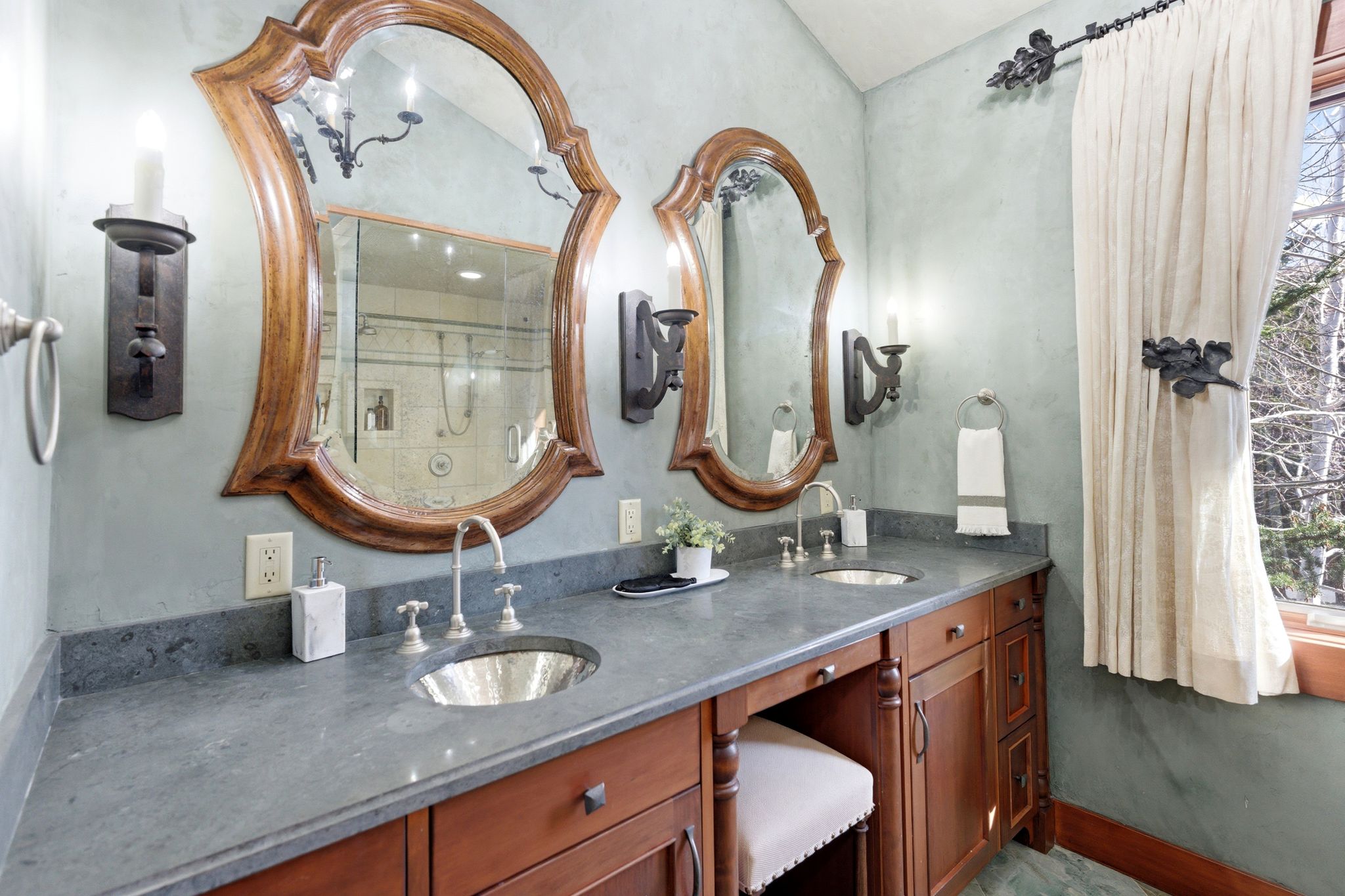 Dual vanity with wood-finish cabinetry and integrated seating area