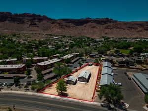 Aerial view showcasing a property with a gray-sided structure and a detached outbuilding