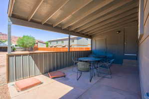 Covered patio with a concrete surface, featuring an exposed beam ceiling structure