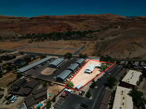 Property parcel featuring a single-story building with a light-colored roof, surrounded by a large open area