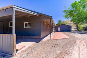 Grey siding exterior with a covered porch and extended concrete walkway