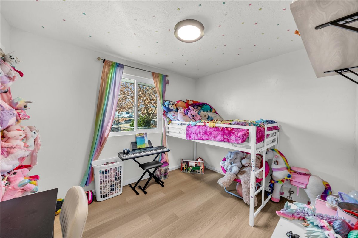 Bright room featuring wood-finish flooring, a white-framed window, and a flush-mount ceiling light
