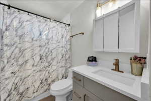 Bathroom featuring a contemporary vanity with an integrated rectangular sink, a brass-finish faucet, and a three-door mirrored medicine cabinet
