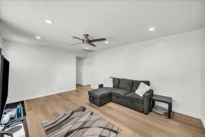Open-concept living space featuring wood-finish flooring, recessed lighting, and a ceiling fan