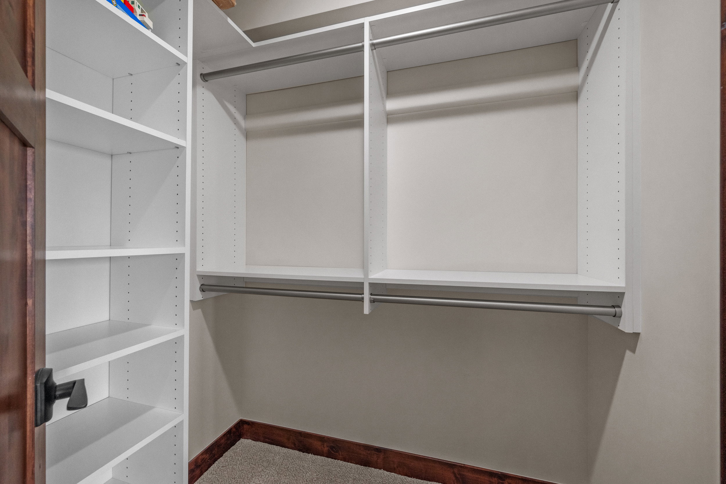 Custom closet system featuring white shelving and hanging rods
