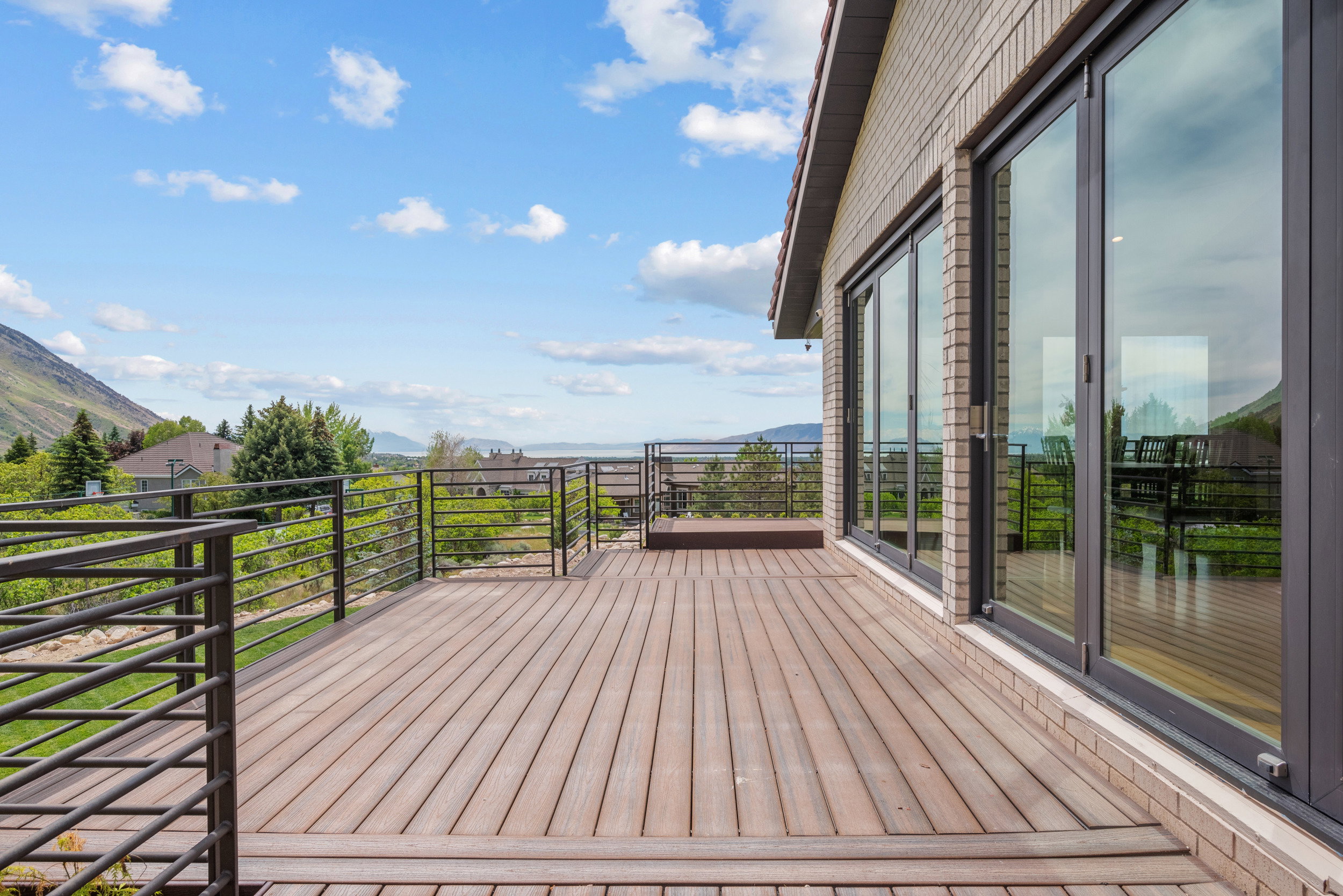 Expansive outdoor deck featuring wood-finish composite decking and a multi-pane sliding glass door system