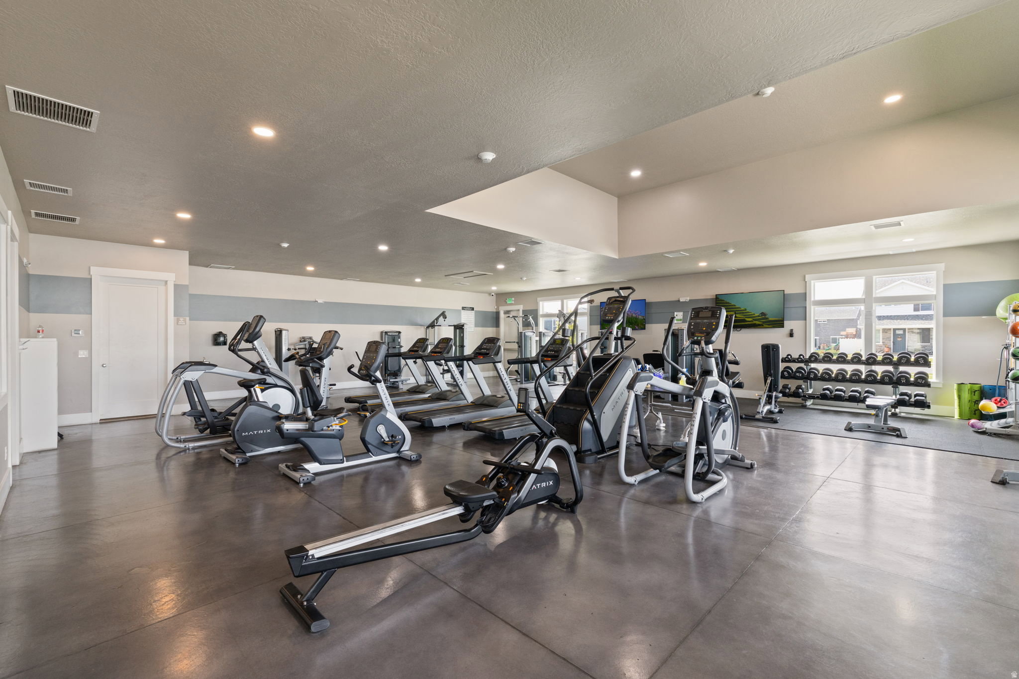 Spacious fitness area featuring durable concrete flooring