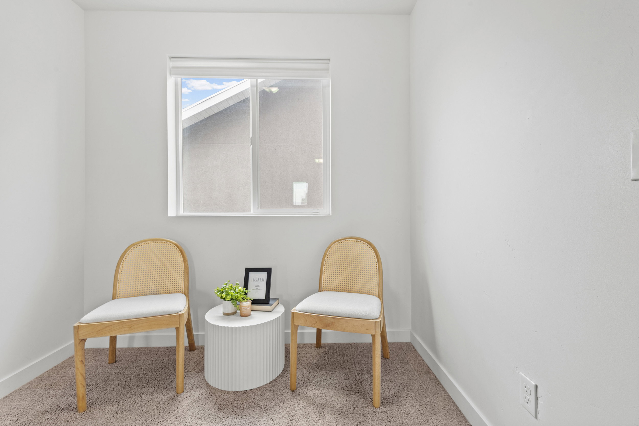 Windowed interior space featuring light-colored carpeting and white walls