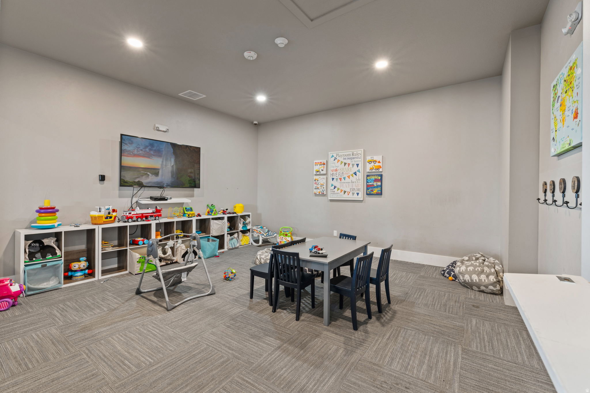Spacious room featuring gray walls and patterned carpet flooring