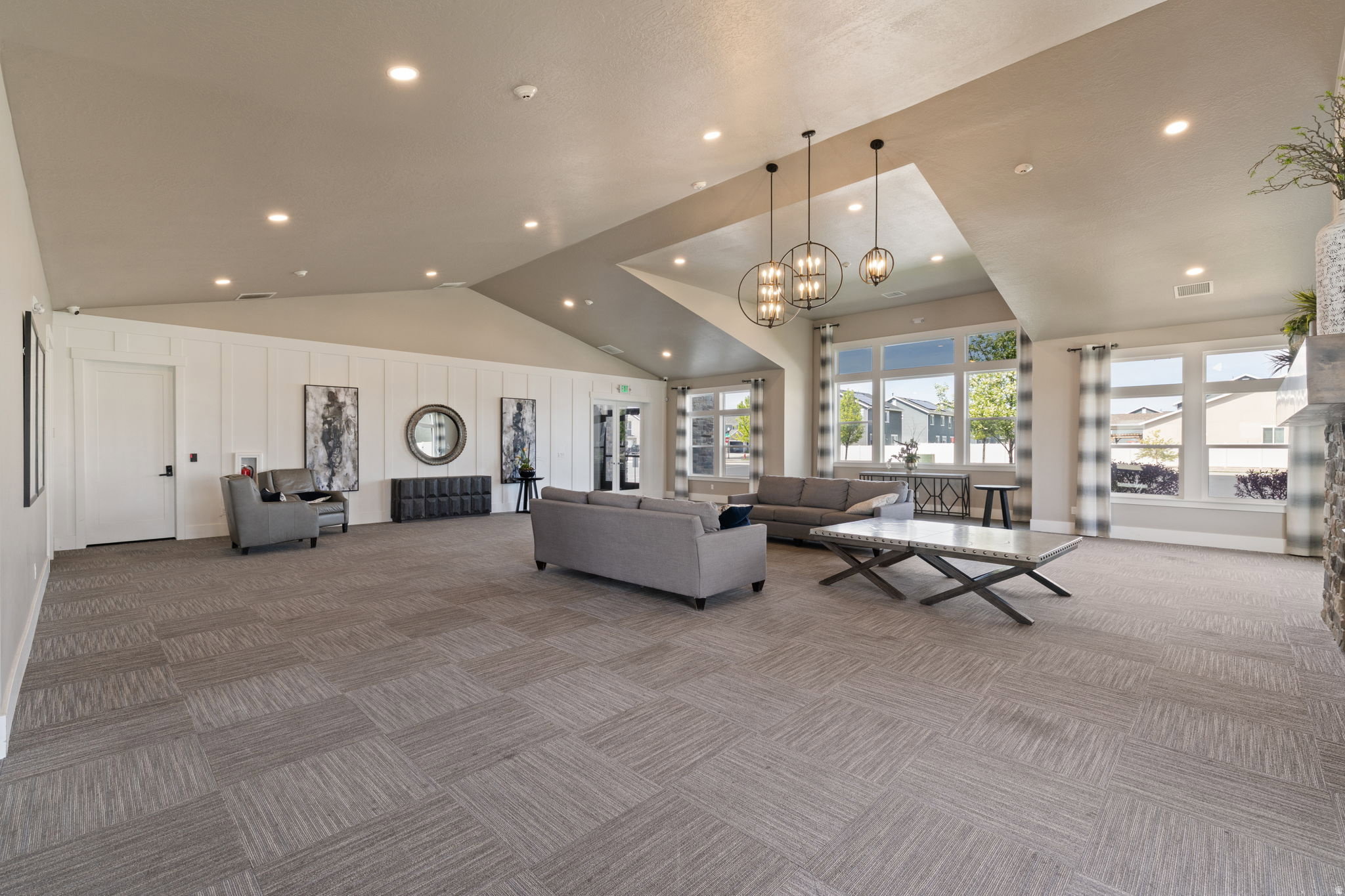 Spacious common area featuring vaulted ceilings, recessed lighting, and large windows providing abundant natural light