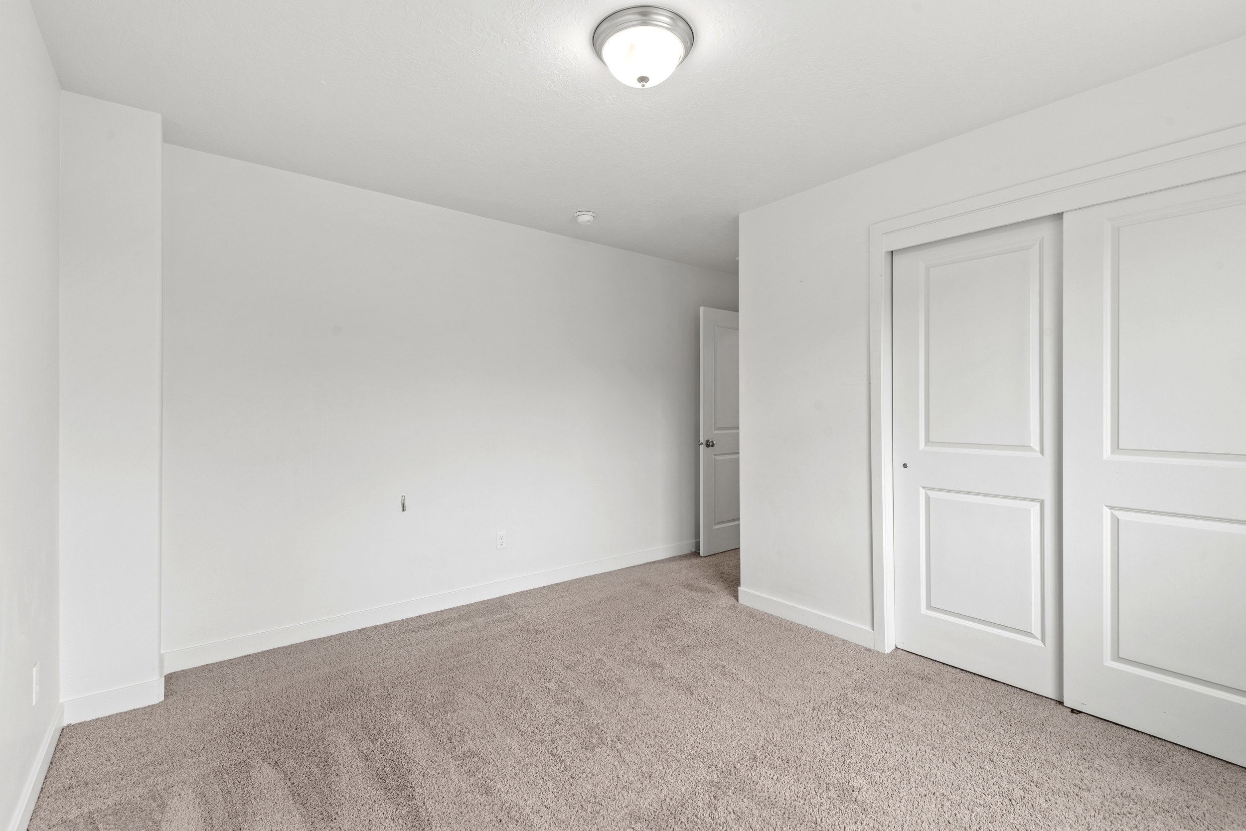 Carpeted room featuring white walls, white trim, and a flush-mount ceiling light fixture