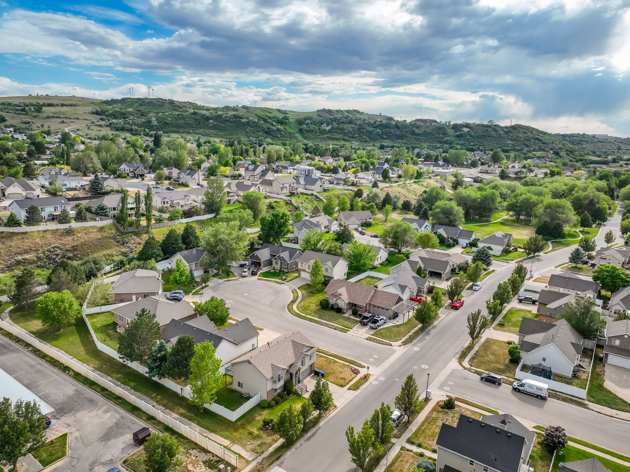 Residential neighborhood with established homes and mature trees, surrounded by natural hillsides