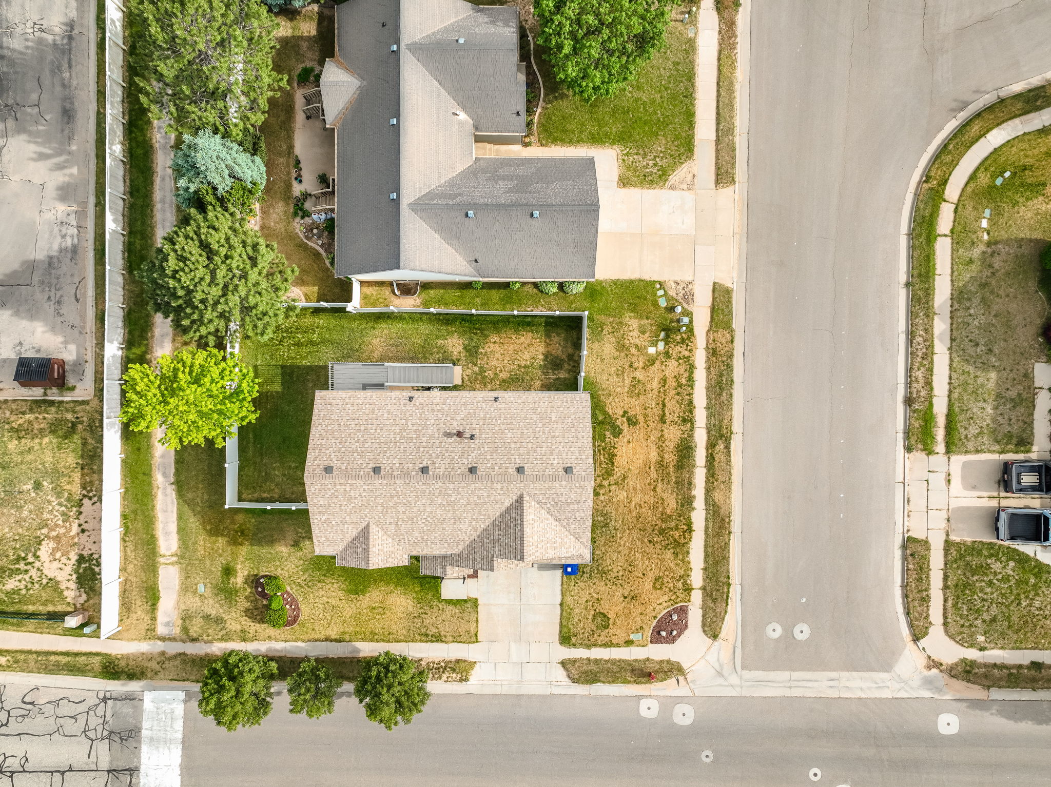 Aerial perspective of a property featuring a tan shingle roof and a concrete driveway