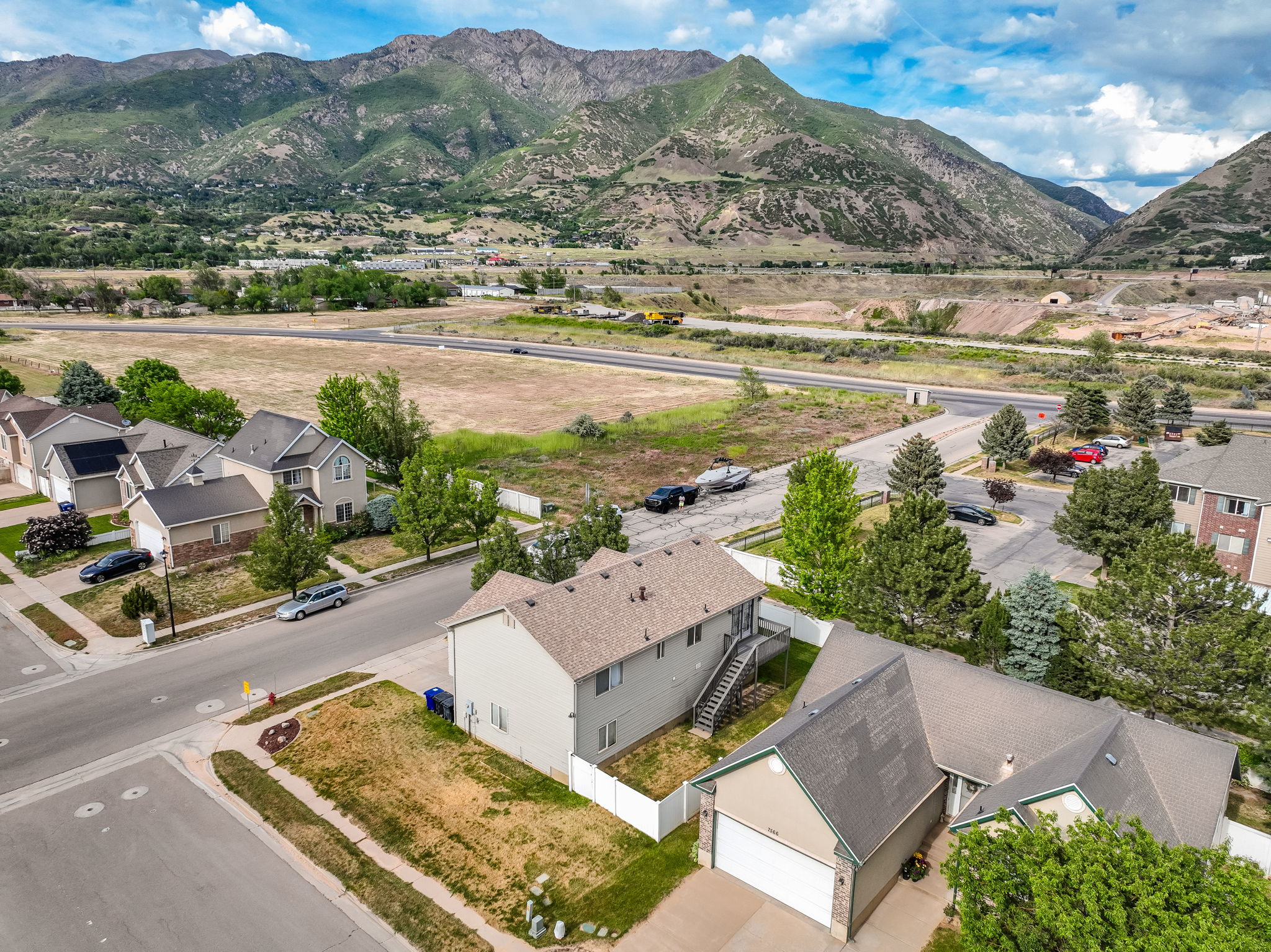 Aerial neighborhood perspective featuring a residential street, mountain backdrop, and varying rooflines
