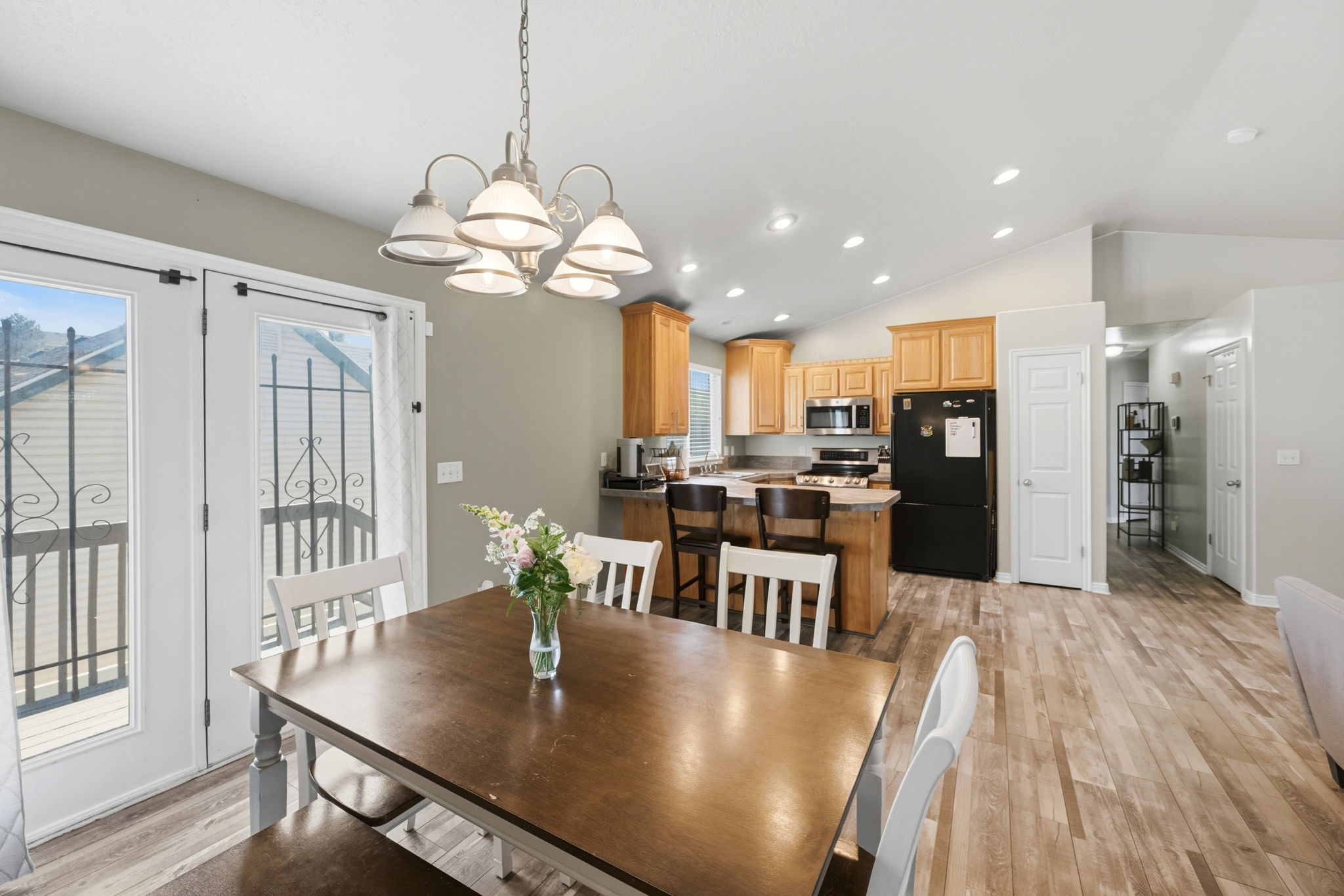 Open-concept living area featuring wood-finish flooring, a vaulted ceiling, and recessed lighting