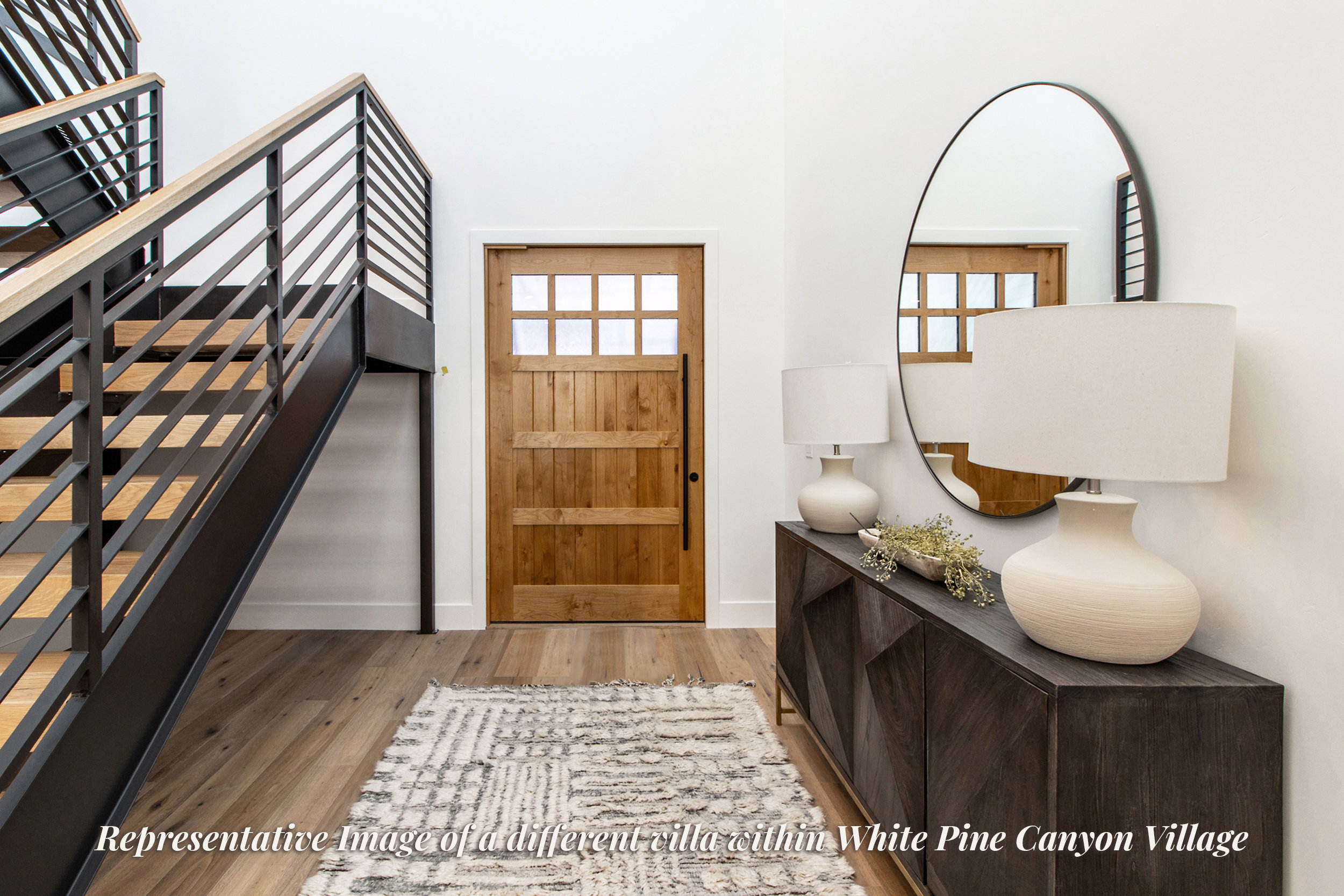 Foyer featuring a natural wood-finish entry door with multiple glass panes, a modern open-riser staircase with black metal railings and wood-finish treads, and wood-finish flooring throughout