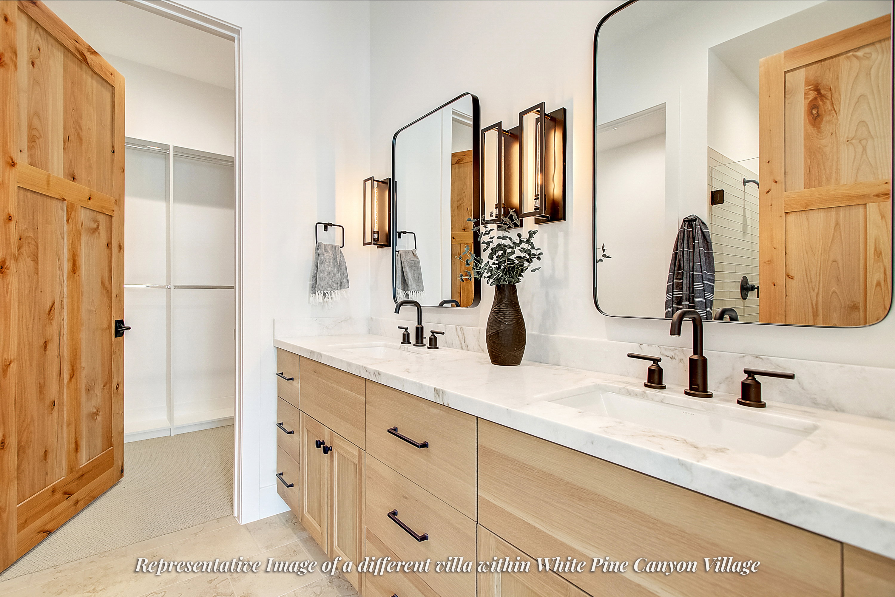 Dual vanity with light wood-finish cabinetry, white stone countertops, and integrated rectangular sinks