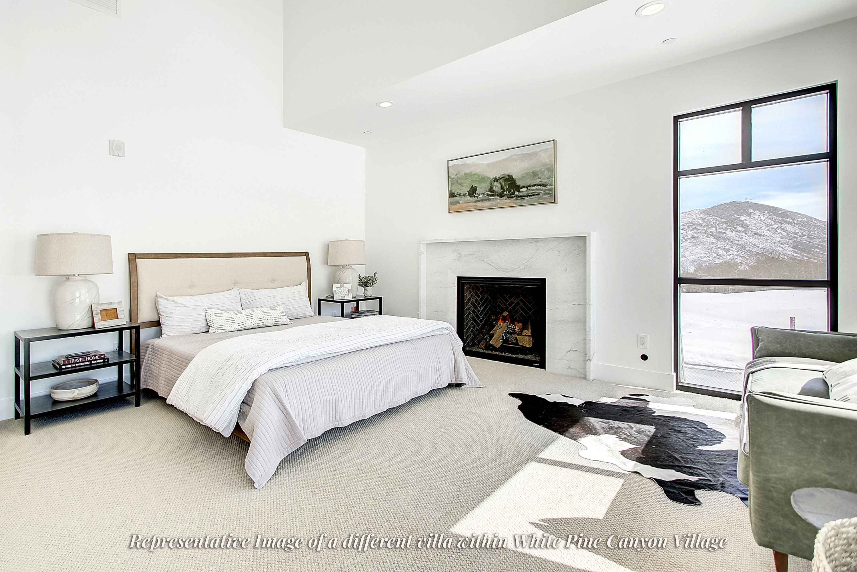 Spacious room featuring a central fireplace with a light-toned stone surround and herringbone-patterned firebox