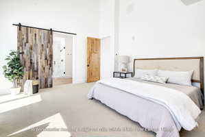 Vaulted ceiling bedroom with light-toned carpeting and white walls