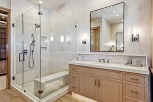 Bathroom featuring a spacious glass-enclosed shower with a built-in bench, dual shower heads, and recessed shelving