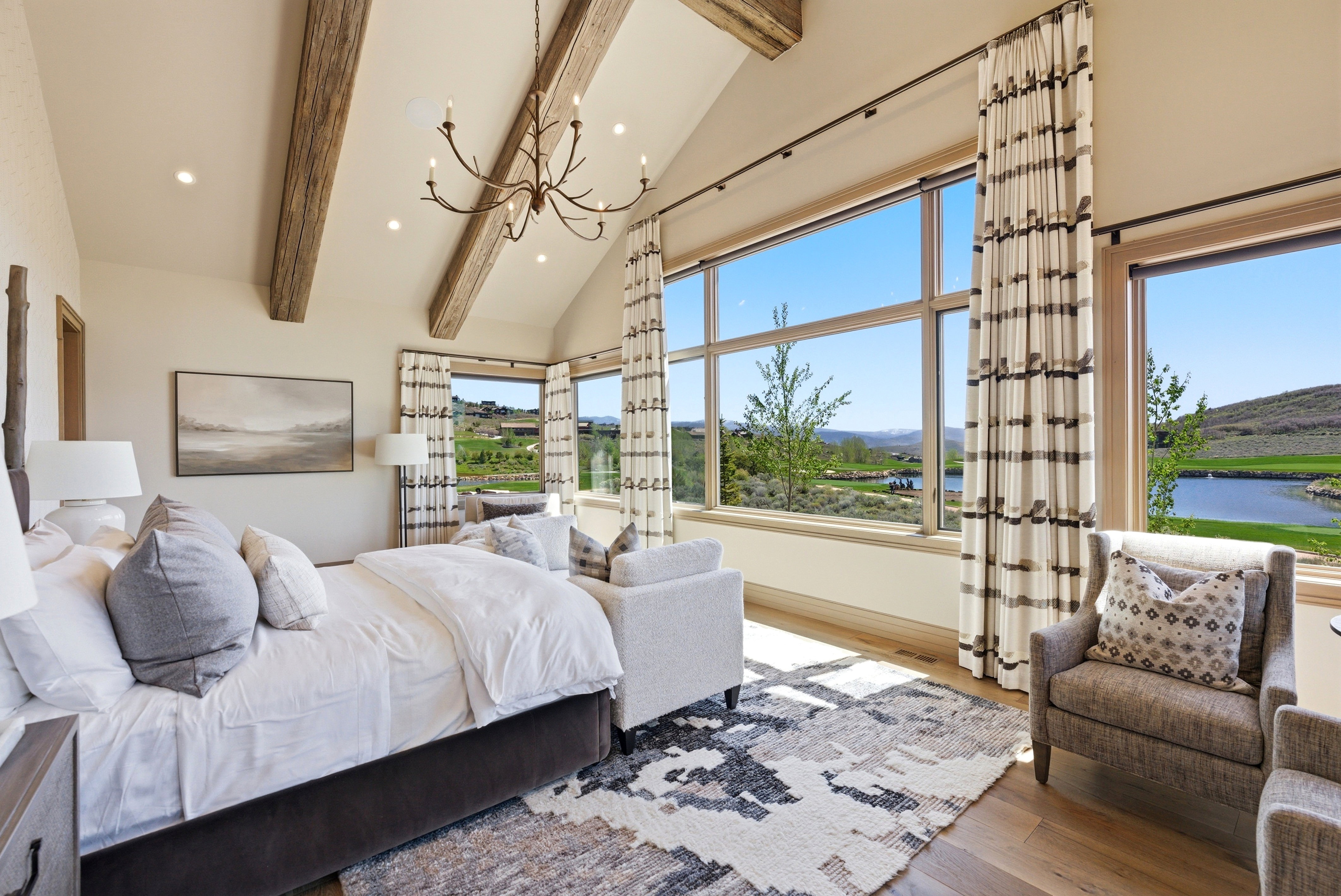 Vaulted ceilings with exposed wood beams and a wrought-iron chandelier