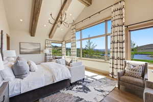 Vaulted ceilings with exposed wood beams and a wrought-iron chandelier