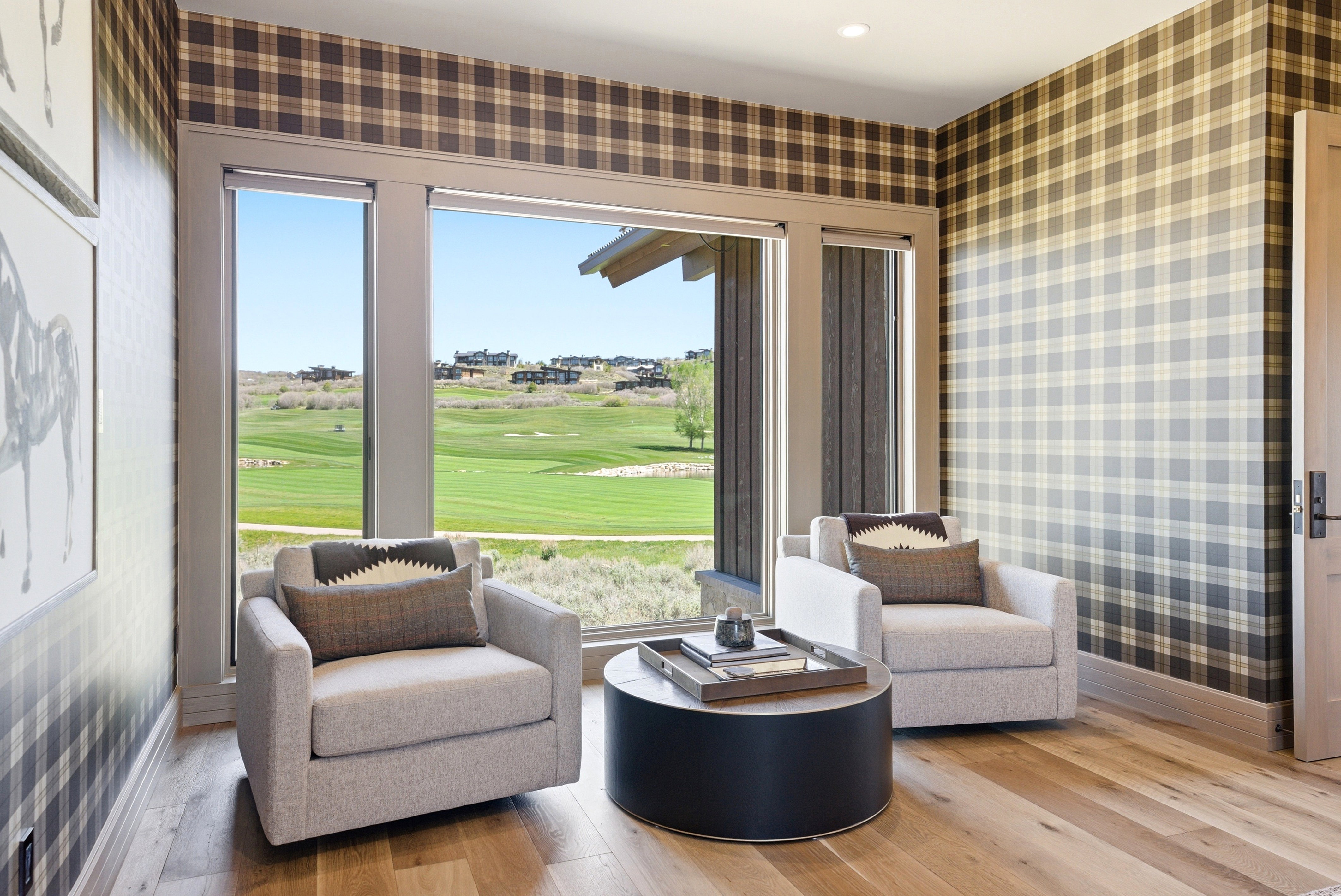 Room featuring floor-to-ceiling windows, wood-finish flooring, and plaid wall coverings